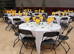 Tables and chairs set up with place settings and decorations